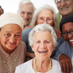 A group of seniors smiling together while in a retirement home